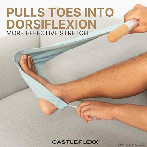 Person using a tool for dorsiflexion stretching on a couch.