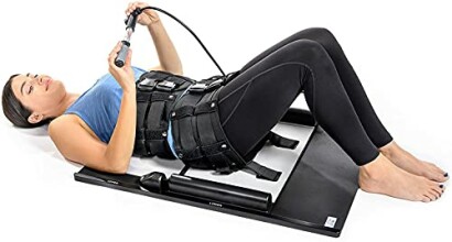 Person using a spinal decompression device while lying on the floor.