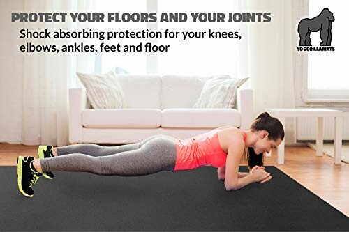 Woman doing plank exercise on a black mat in a living room.